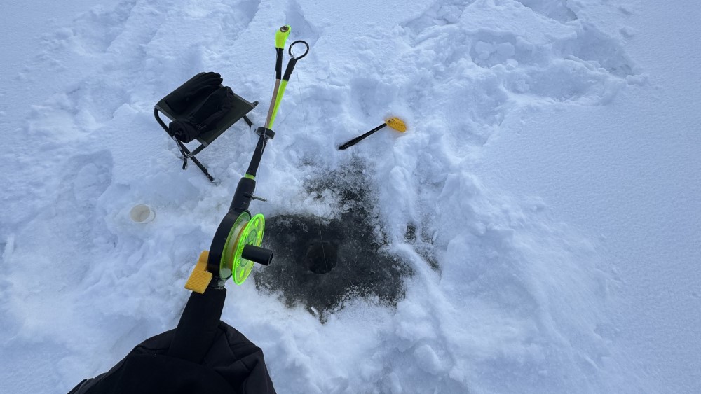 Vissen door een gat in het ijs.